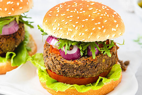 A plant based burger in a bun with salad