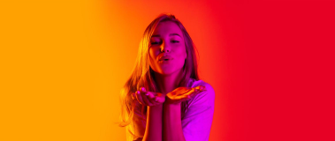 Woman with her hands under her face making a blowing gesture