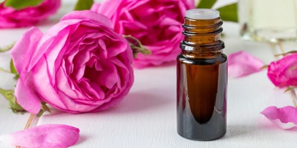 Roses on a table with essential oil bottle on the table