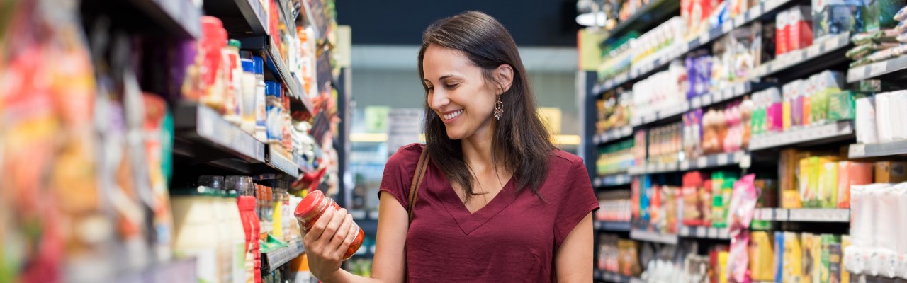 Woman in a grocery store reading nutrition labels